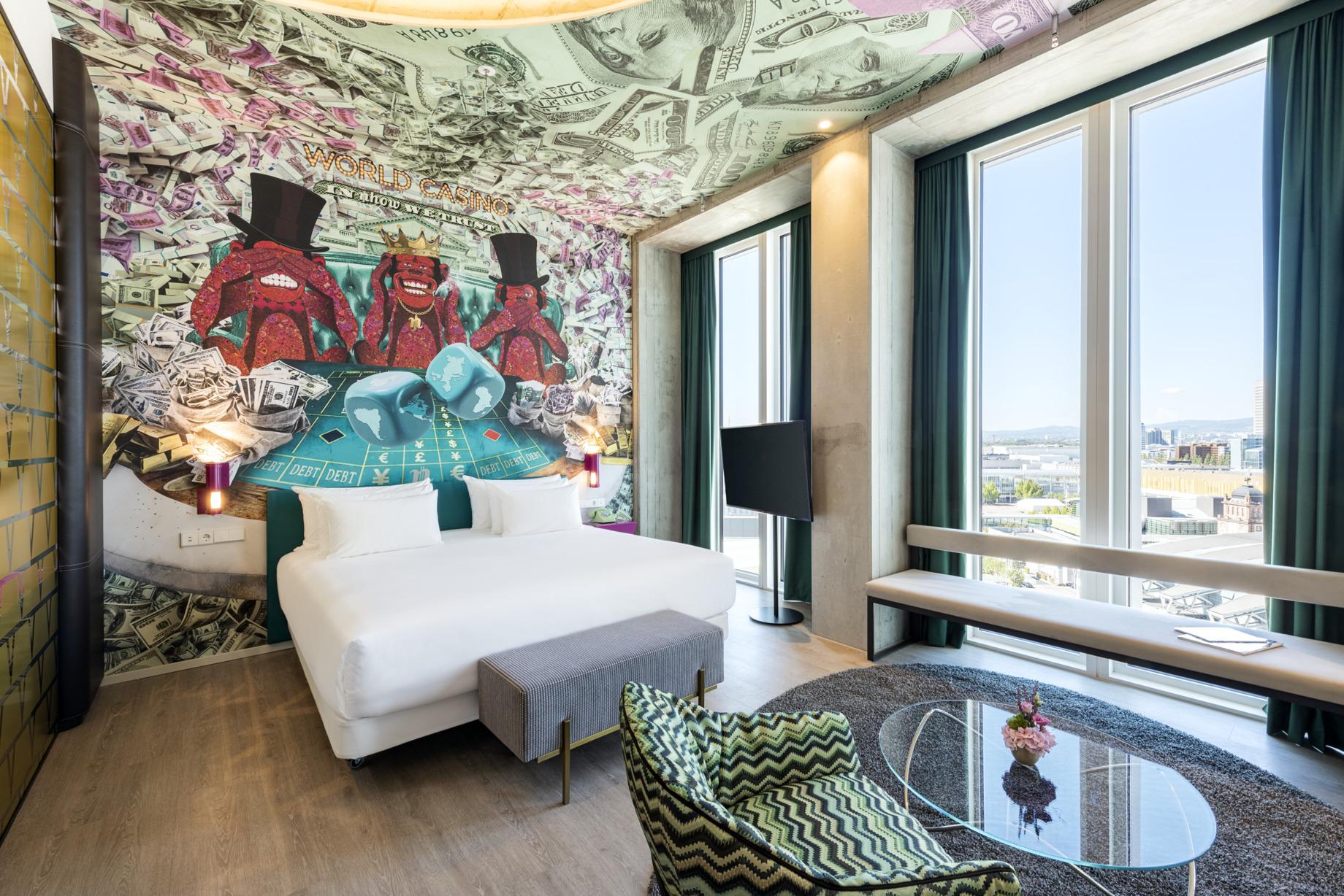 nhow_Frankfurt_Room_junior_suite_curtains_open_king_size_bed_armchair_glas_table_flow